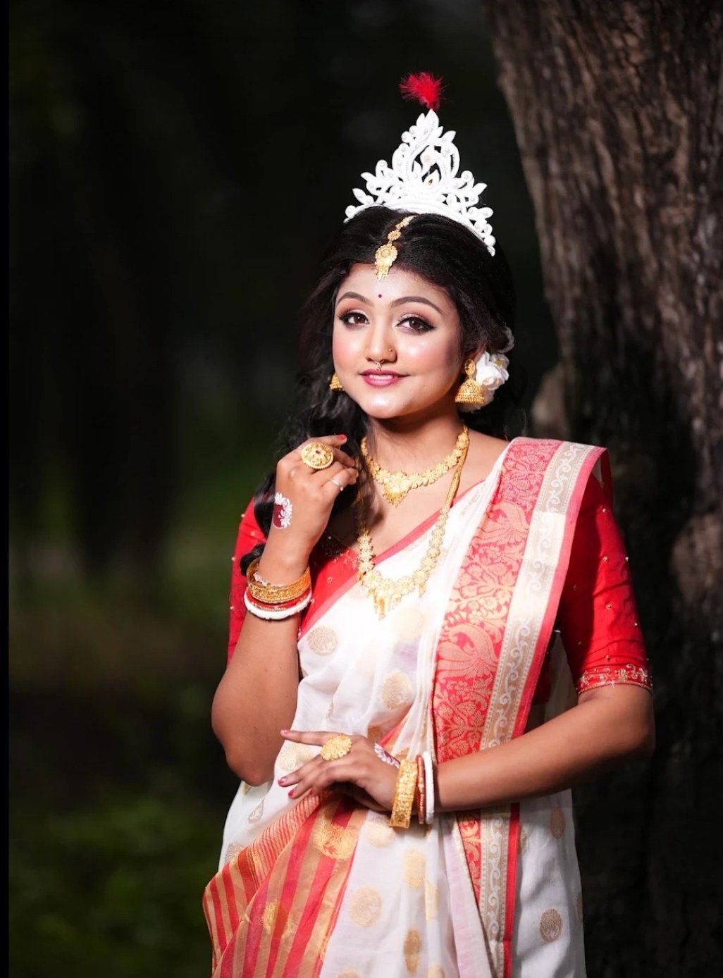 Bride in white and red sari with traditional bridal makeup